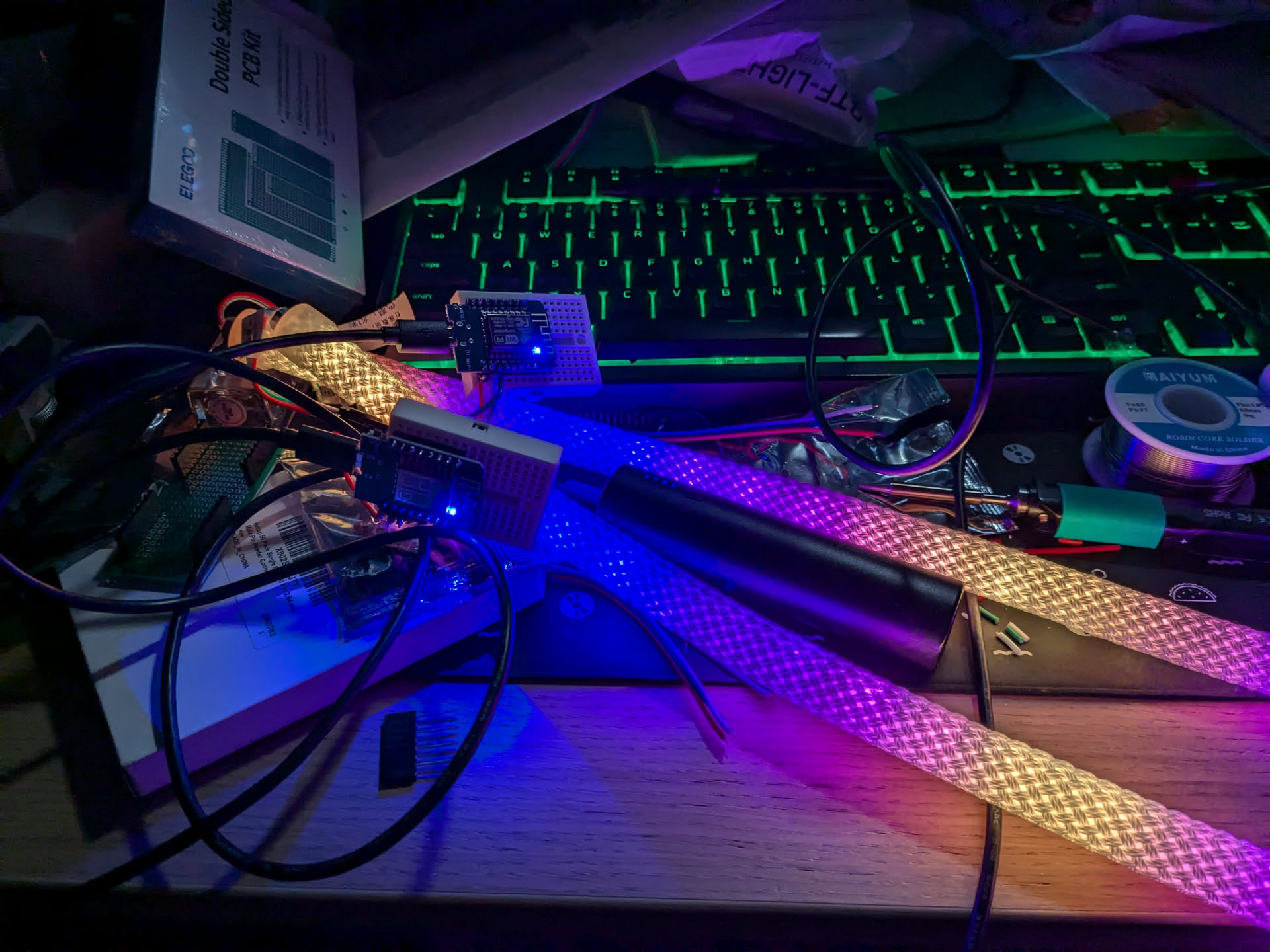 photograph of LED tubes connected to ESP32 boards showing brightness on a messy desk
